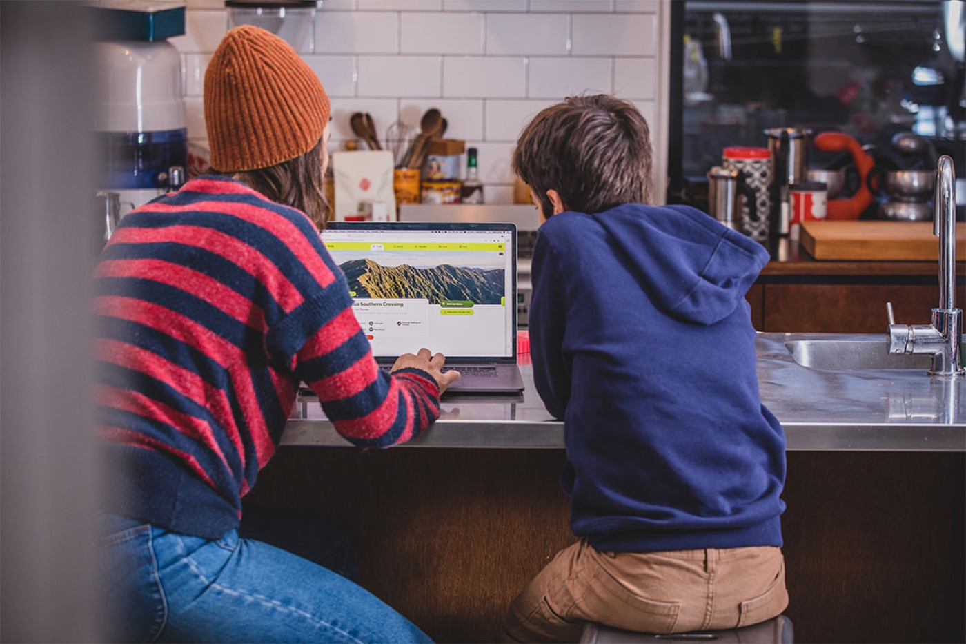 A woman and a boy looking at the Plan My Walk website on a laptop
